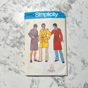 May include: Vintage Simplicity sewing pattern 7080 for men's robes. The pattern features illustrations of three different robe styles in various colours, including a plaid, yellow, and red robe. The pattern size is Large, 107-112 cm.