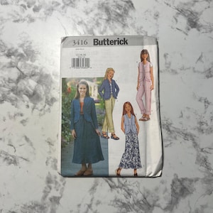 May include: A Butterick sewing pattern packet featuring illustrations of women's clothing designs. The packet includes a blue jacket and dress, a blue jacket with yellow pants, a pink pantsuit, and a blue vest with a floral skirt. The packet has the number 3416.