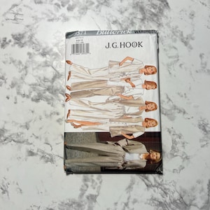 May include: A vintage Butterick sewing pattern featuring a J.G. Hook wardrobe. The cover displays illustrations of women in various outfits, including pantsuits, skirts, and jackets. The color palette includes beige, white, and brown.