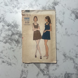 May include: Vintage Vogue pattern envelope featuring illustrations of two women in mini dresses. The envelope is tan with the number 7858 at the top. The text "VOGUE PATTERN" is visible, along with size information.