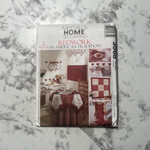 以下が含まれることがあります： 「Redwork: An American Tradition」というタイトルのMcCall's Home Decoratingパターン。 テーブルクロス、カーテン、鍋つかみなど、赤と白のホームデコレーションアイテムが特徴です。 パターン番号は3068です。