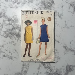 May include: Vintage sewing pattern for a dress, Butterick 5272, size 12, bust 34, with New Sizing. The pattern features two dress styles, one yellow and one blue, with a simple, sleeveless design.