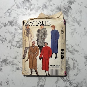 Puede incluir: Sobre de patrón de costura vintage de McCall's con ilustraciones de abrigos de mujer en varios estilos. El sobre es de color beige con el logotipo de McCall's y el número de patrón 9229. Incluye el texto "PETITE-ABLE" y "MISS SIZE".