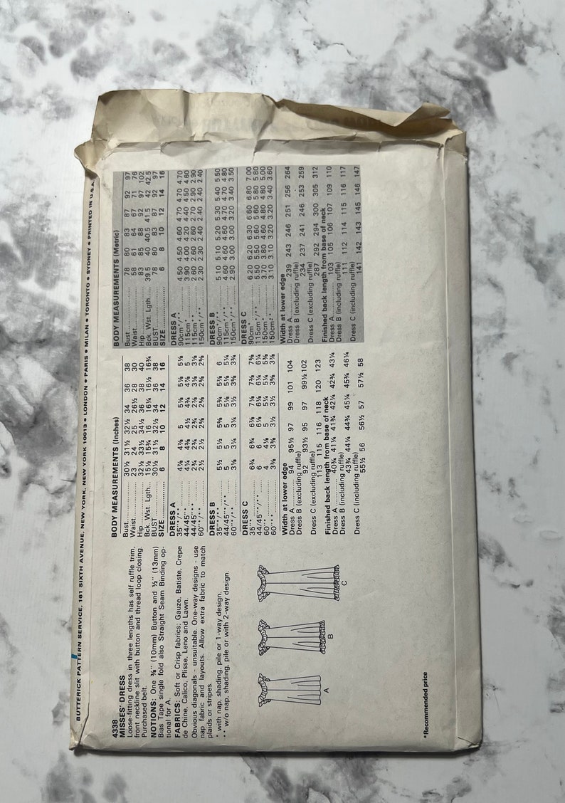 May include: A sewing pattern for a loose-fitting dress with a self ruffle trim. The pattern includes three different dress lengths and a chart with measurements for each size. The pattern is for sizes 6-16.
