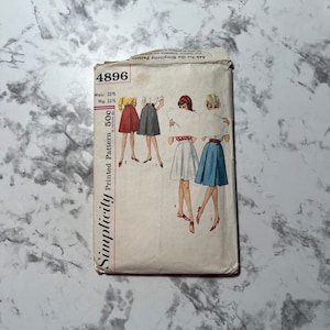 May include: Vintage Simplicity pattern envelope, featuring illustrations of skirts in various colors. The envelope displays the number 4896, waist size 23.5 inches, and hip size 32.25 inches. The text "Simplicity Printed Pattern 50c" is also visible.