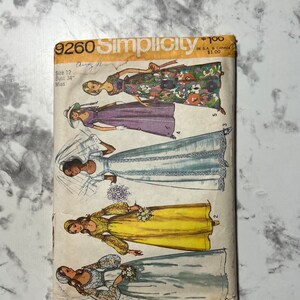 Könnte beinhalten: Vintage Simplicity Schnittmuster Nummer 9260 für eine Größe 12, Brustumfang 86 cm, Fräulein. Das Schnittmuster enthält drei verschiedene Kleidstyles: ein Kleid mit Blumenmuster, ein lila Kleid und ein weißes Kleid mit Spitze.