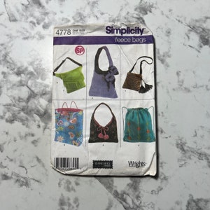 Puede incluir: Patrón de costura Simplicity 4778 para bolsas de forro polar. El patrón incluye instrucciones para seis bolsas diferentes, incluyendo una bolsa hobo, una bolsa de cordón y una bolsa de hombro. El patrón está diseñado por Elaine Heigl Designs y está disponible en una talla.