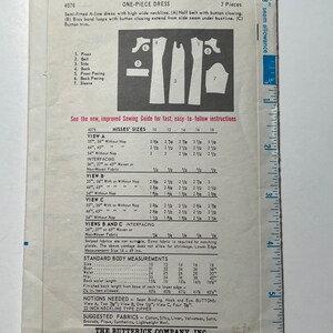 May include: A vintage sewing pattern for a one-piece dress with a high neckline and a half belt. The pattern includes instructions for sizes 10-18 and is from the Butterick Company, Inc. The pattern is printed on white paper with black text and illustrations.