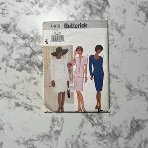 May include: A vintage Butterick sewing pattern packet, featuring illustrations of women's suits. The packet has the number 3400 printed on it, with the Butterick logo. The suits are in white, pink, and blue. The background is a marble pattern.