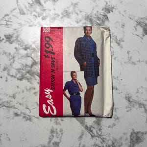 May include: A vintage sewing pattern with a red and white stripe on the left side, featuring the text "Easy Stitch 'N Save". The pattern shows a woman in a blue dress and a blue and black plaid jacket.