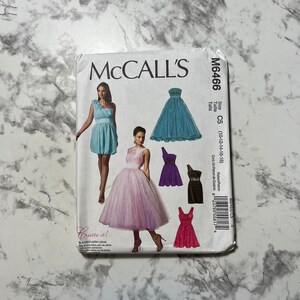 Puede incluir: Un patrón de costura para un vestido con una variedad de estilos. El patrón es para las tallas 10-12-14-16-18. El patrón se llama McCall's M6466.