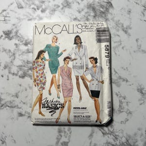 May include: McCall's sewing pattern for a blazer and skirt. The pattern is for sizes 6-14 and includes instructions for making a petite-able version. The pattern is for a double-breasted blazer with a skirt that can be made in a variety of fabrics. The pattern is called "Fashion Basics" and is size C.