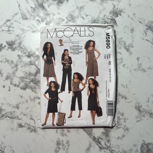 Puede incluir: Patrón de costura McCall's M5890 para las tallas 6-8-10-12-14. El patrón incluye cinco estilos de vestidos diferentes, incluyendo un vestido sin mangas, un vestido con manga corta y un vestido con manga larga. El patrón está impreso en un fondo blanco con texto e imágenes negras.