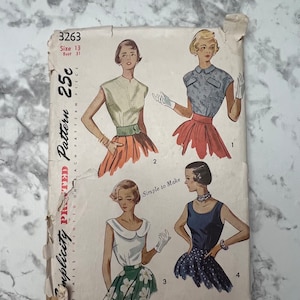 Könnte beinhalten: Vintage Simplicity Schnittmuster Nummer 3263, Größe 13 Brustumfang 31, für ein 25 Cent Muster. Das Muster enthält vier verschiedene Stile von Oberteilen mit kurzen Ärmeln. Die Oberteile werden an vier verschiedenen Modellen gezeigt. Das Muster ist auf weißem Hintergrund mit schwarzem Text gedruckt.