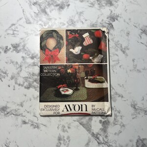 May include: A vintage Avon tapestry pattern collection featuring a Christmas wreath, stocking, dove, and bird ornaments. The package is designed exclusively for Avon by McCall Patterns.