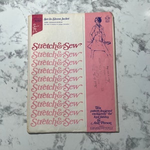 May include: Vintage sewing pattern for a set-in sleeve jacket. The cover features the text "Stretch & Sew" in a pink script, along with an illustration of a woman in a jacket and skirt. The pattern is designed for knit fabrics.