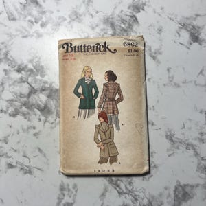 May include: A vintage Butterick sewing pattern envelope. The envelope features illustrations of three different coat designs. The text on the envelope includes "Butterick", "The Fashion One", and the size and bust measurements.