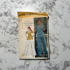 May include: Vintage Simplicity sewing pattern featuring a woman in a blue pantsuit and another in a yellow top and white pants. The pattern is labeled "Young Contemporary Fashion" and includes size information.