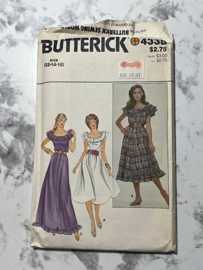 May include: A vintage sewing pattern for a dress with three different styles. The pattern is for sizes 12-14-16. The dress is shown in three different colors: purple, white, and plaid. The pattern is from Butterick and the number is 4338.