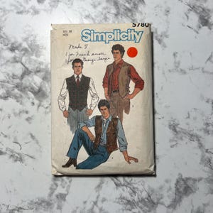 May include: Simplicity sewing pattern number 5780 for a vest. The pattern shows three men wearing different styles of vests. The pattern is for sizes 38 and up.