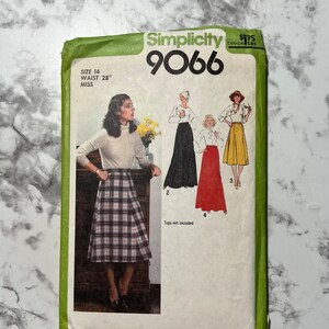 May include: Vintage Simplicity sewing pattern number 9066 for a skirt. The pattern is for size 14 with a 28 inch waist. The pattern shows three different skirt styles, one with a plaid print, one black, and one yellow.