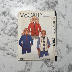 May include: McCall's sewing pattern for a girl's size 14 jacket and vest. The pattern is quick and easy to sew. The jacket is blue with red trim and the vest is white with a tie closure.