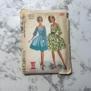 May include: Vintage McCall's sewing pattern for a misses' dress. The pattern features illustrations of two dresses, one blue and one green with a floral pattern. The pattern is labeled "Easy" and includes the McCall's logo and text.