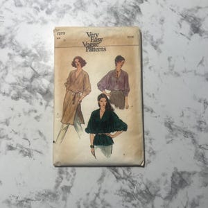 May include: Vintage sewing pattern for a blouse with three different styles. The pattern is from Vogue and is labeled "Very Easy Vogue Patterns".