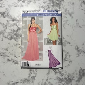 May include: Simplicity sewing pattern 1908 P5 featuring Jessica McClintock designs. The pattern includes images of strapless formal dresses in shades of pink, green, and purple. The pattern envelope is white and blue.