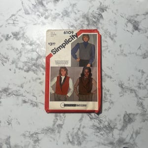 May include: Simplicity sewing pattern number 6109 for a vest. The pattern is for sizes 14 to 22 and is priced at £3.00. The pattern shows three different styles of vests, all with a button-up front.