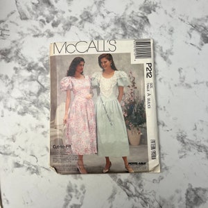 Puede incluir: Patrón de costura McCall's para un vestido, talla A (6, 8, 10). El patrón es para un vestido con mangas abullonadas y un ribete de encaje. El patrón está etiquetado como "Cut-to-Fit" y "Petite-Able".