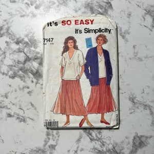 May include: A Simplicity sewing pattern for a skirt and top. The pattern number is 7147 and the size is 8-20. The pattern shows two women wearing the skirt and top. One woman is wearing a blue jacket over the top.