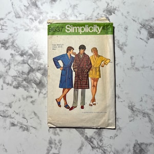Puede incluir: Un patrón de costura Simplicity para una bata, con una talla de pecho de 96,5 a 101,6 cm. El patrón muestra a tres hombres usando batas de diferentes colores, una azul, una a cuadros y una amarilla.