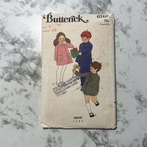 May include: A vintage sewing pattern for children's clothing. The pattern is for a toddler's coat and includes instructions for sizes 1, 2, 3, and 4. The pattern is from Butterick and is number 6166. The pattern is 75 cents.