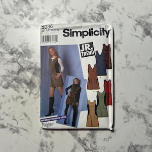 May include: A Simplicity sewing pattern for a junior's dress. The pattern includes four different styles of dresses, all with a sleeveless design. The pattern is for sizes 7/8-15/16. The pattern is labeled "JR. TREND".