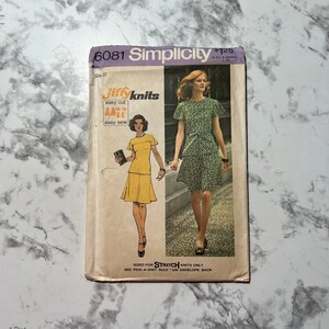 May include: Simplicity sewing pattern number 6081 for a dress, featuring a model wearing a green and white floral print dress with short sleeves. The pattern is for stretch knits only and includes instructions for easy cutting and sewing. The pattern is priced at $1.25.