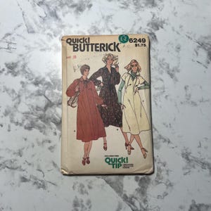 May include: Vintage Butterick sewing pattern envelope featuring illustrations of three women in dresses. The envelope is cream-colored with the text "Quick! Butterick" and the pattern number 6249. The illustrations depict dresses with various styles.