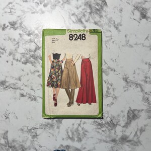 May include: Simplicity sewing pattern number 8248 for size 10 with a 25 inch waist. The pattern includes three different skirt styles: a floral print skirt, a brown culottes skirt, and a red maxi skirt.