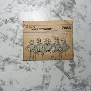 May include: A vintage McCall's sewing pattern envelope. The tan envelope features the text "MAKE IT TONIGHT" and a drawing of five women in blouses and skirts. The price is marked as 75¢.