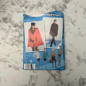 May include: A blue Simplicity Runway sewing pattern packet featuring illustrations of coats and capes. The packet includes size information and a barcode. The main image shows a woman wearing a red cape.