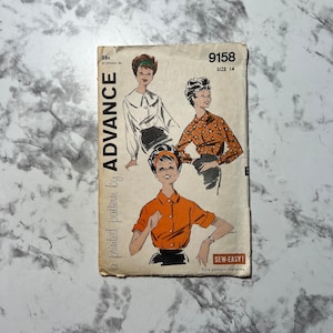 May include: Vintage sewing pattern for a blouse, size 14, from Advance pattern company. The pattern features three different styles of blouses with collars and button closures. The pattern is printed on light brown paper with a white background.