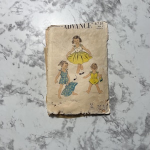 May include: Vintage Advance 6751 sewing pattern featuring illustrations of children's clothing designs. The pattern includes drawings of a yellow dress, blue romper, and yellow romper. The pattern is size 2 with a 31-inch bust.