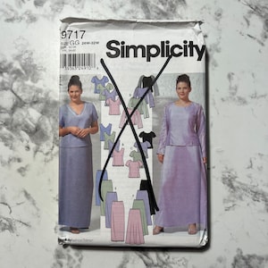 May include: Simplicity sewing pattern number 9717 for sizes GG 26W-32W. The pattern includes instructions for making a two-piece outfit with a skirt and a top. The pattern is illustrated with a model wearing a lavender skirt and top.