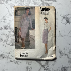 Puede incluir: Un patrón de costura vintage de Vogue American Designers con una mujer con traje de falda y otra con falda y blusa. El patrón es de Joseph Picone, con el número 2696. La portada es blanquecina con aspecto desgastado.