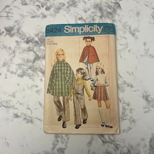 May include: Vintage Simplicity sewing pattern number 8424 for a girl's cape, pants, and skirt. The pattern is for size 10 with a 28 1/2 inch bust.