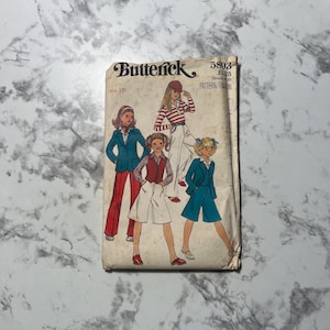 May include: Vintage sewing pattern for girls' clothing, featuring four different outfits. The pattern is from Butterick and is size 10. The pattern number is 5893 and the price is $1.25.