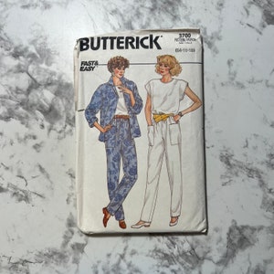 Könnte beinhalten: Ein Vintage-Schnittmuster von Butterick mit zwei Hosenmustern für Damen. Das Muster ist mit "Fast & Easy" gekennzeichnet und umfasst die Größen 14-18. Das Muster ist für eine weiße Hose mit breitem Bund und eine blaue Blumenhose mit passender Jacke.