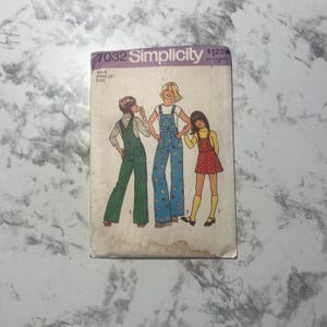 May include: Vintage Simplicity sewing pattern 7032. The pattern features illustrations of three children wearing overalls and a dress. The pattern is for a size 4 child with a 23-inch waist.