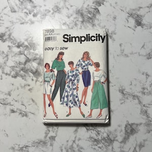 May include: Simplicity sewing pattern with illustrations of women's clothing designs. The pattern packet shows tops, skirts, trousers, and dresses. The text "easy to sew" is displayed on the front of the packet.