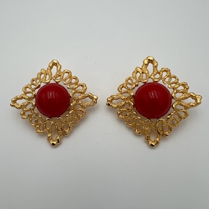 Vintage brutalist style gold tone clip earrings with red cabochon center